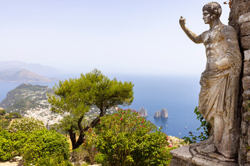 Statue of Emperor Augustus on Monte Solaro and view of rocks Faraglioni, Capri Island, Italy