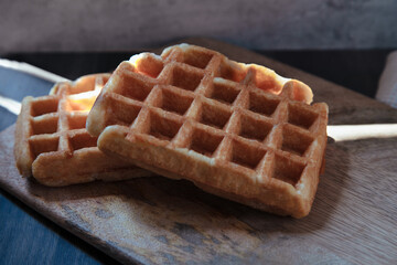 Close-up view of two artisan waffle over wood table