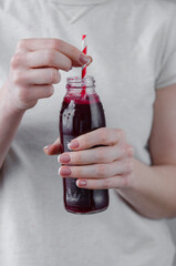 woman drinks fresh beetroot from a bottle. Vegetable juice. Drink a drink through a straw.