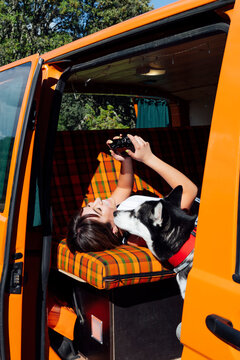 Traveling woman looking through photos on camera in van