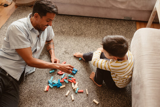 Father and son playing with construction pieces in the dining room