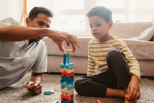 Father and son playing with construction pieces in the dining room