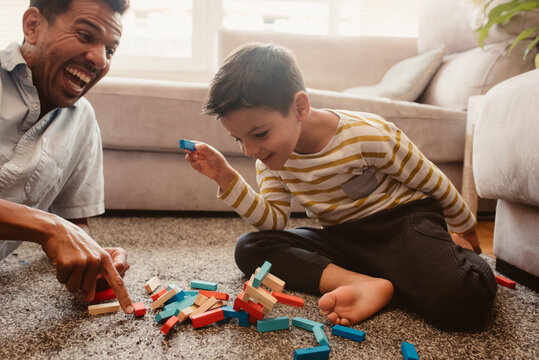 Father and son playing with construction pieces in the dining room