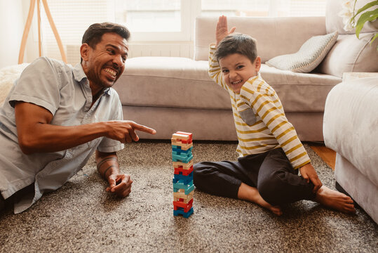 Father and son playing with construction pieces in the dining room