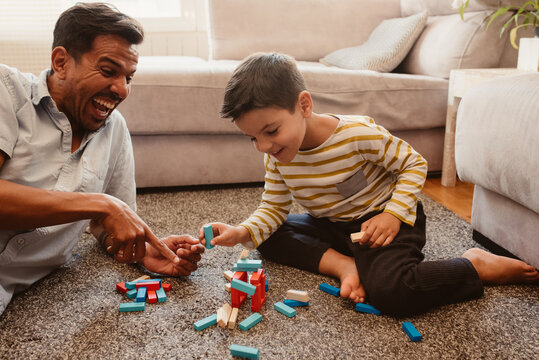 Father and son playing with construction pieces in the dining room