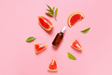 Composition with bottle of essential oil and grapefruit slices on color background
