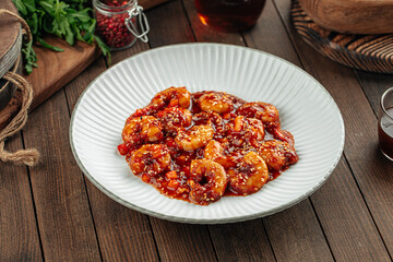 Shrimp with sweet sauce and sesame seeds dish on a wooden background