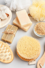 Massage brushes and different bath supplies on grey background