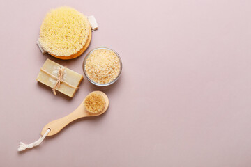 Different massage brushes and bath supplies on color background