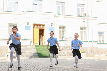 Fototapeta na wymiar Cute little schoolgirls after classes outdoors