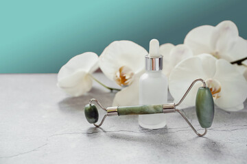 Serum or essential oil bottle with guasha massage roller for spa and natural skin care, body and...