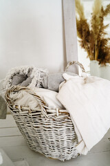 Fototapeta na wymiar White wicker basket with blankets