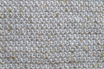 The texture of a knitted gray fabric with sequins