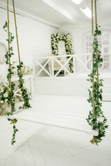 White swing with artificial flowers
