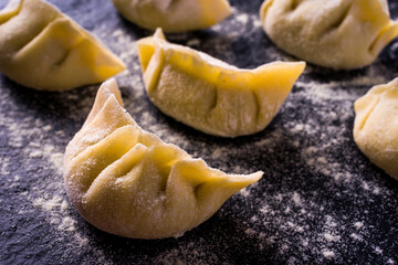 preparing Japanese ravioli close up, over dark stone table. Asian cuisine