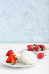 Plate with tasty Japanese mochi and strawberry on light background