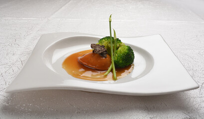 braised single whole big abalone seafood with vegetable and black truffle , ginseng in chef oyster...