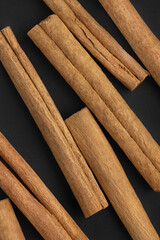 Closeup top view of cinnamon rolls, black background. Spices, backgrounds and textures.