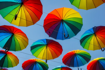 Rainbow multi-colored umbrellas from the rain on the background of the sky.