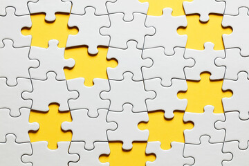Missing puzzle pieces on yellow background.