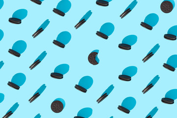Creative isometric concept made of pattern of chocolate chip cookies  on pastel blue background. Black circular biscuits. Geometric art layout. Top view. Flat lay.