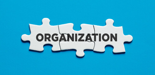 The word organization on connected jigsaw puzzle pieces. To organize in business