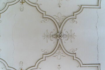 Round antique vintage decorative clay stucco relief molding with floral ornaments on white ceiling...