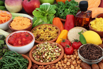 Healthy food for clean eating vegan diet high in protein, omega 3, vitamins, minerals, antioxidants, anthocyanins, fibre. Vegetables, fruit, olive oil, grains, dips, oatmeal crackers, black tea, nuts.