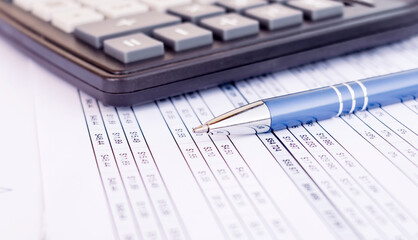 Financial accounting. Pen and calculator on balance sheets