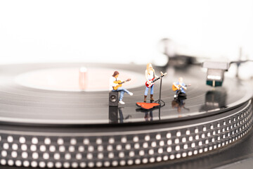 Trio miniature guitarist on a vinyl record player