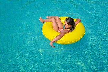 Real adorable girl relaxing in swimming pool