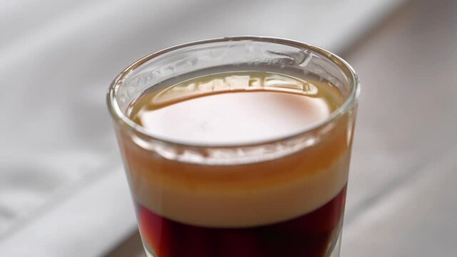 A Glass Of B-52 Cocktail Drink. Layered Shot Of Coffee Liqueur, Irish Cream, And Grand Marnier. closeup