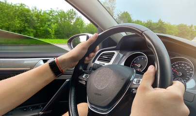 A man driving a car passing by a beautiful forest landscape. Car rental