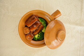 braised sea cucumber with scallop and broccoli in thick oyster sauce in hot clay pot asian premium halal menu