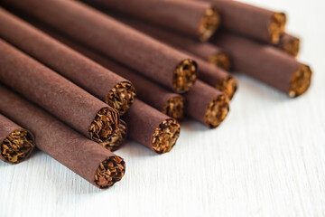 Cigarettes wrapped in brown paper, on a white background close-up