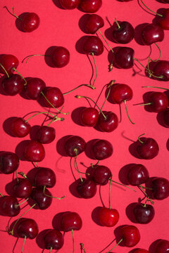 Ripe red cherries on pink background