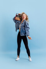 Portrait of attractive young girl in retro 90s fashion style, outfits posing isolated over blue...