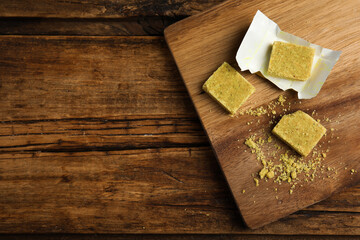 Bouillon cubes on wooden table, top view. Space for text