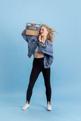 Portrait of attractive young girl in retro 90s fashion style, outfits posing isolated over blue...