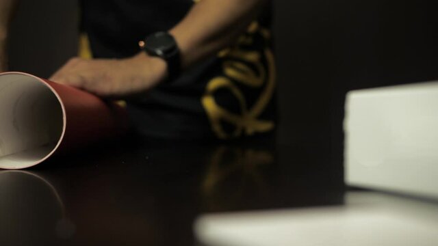 Man rolling red vinyl. Car wrap