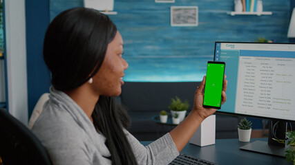 Student with dark skin holding phone with mock up green screen chroma key looking at isolated...