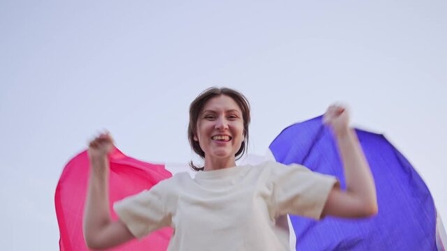 Portrait of an emotional woman with the flag of France. Football fan. Olympic fan