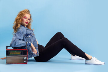 Portrait of attractive young girl in retro 90s fashion style, outfits posing isolated over blue...