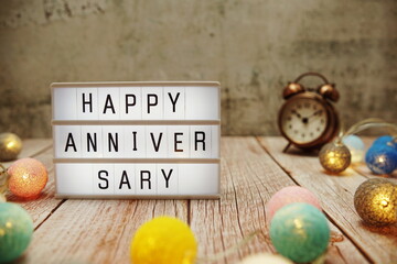 Happy Anniversary text on lightbox on wooden background