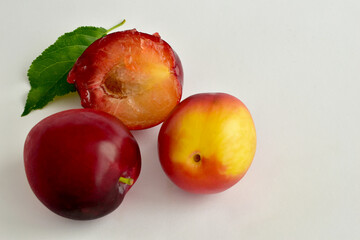 Ripe, juicy cherry plum fruits in the amount of two and one half of this fruit lie on a white table