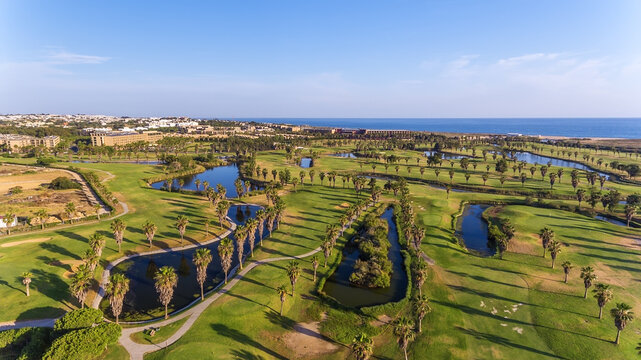 Green golf courses by the sea. Salgados beach. Portugal, Albufeira. Aerial view.