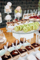 Candy bar. Beautiful multi colored decorated candy table baked sweet tasty cupcake cupcakes on a party. Beautifully decorated catering banquet table with different candy sweet delicacy.