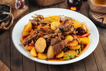 Uzbek dish kazan kabob with lamb and potatoes on a wooden background