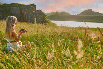 Blonde girl practicing meditation with tibetan bowl at dawn