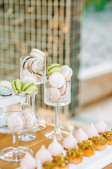 Fototapeta na wymiar French macaroons in a glass stand . Candy bar on wedding.